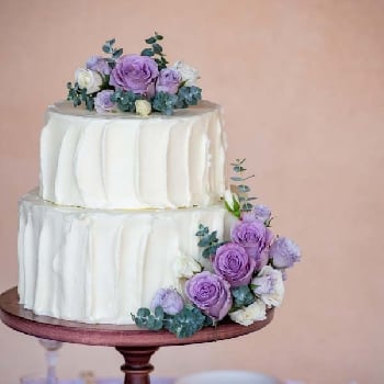 White Wedding Cake With Purple And White Roses.